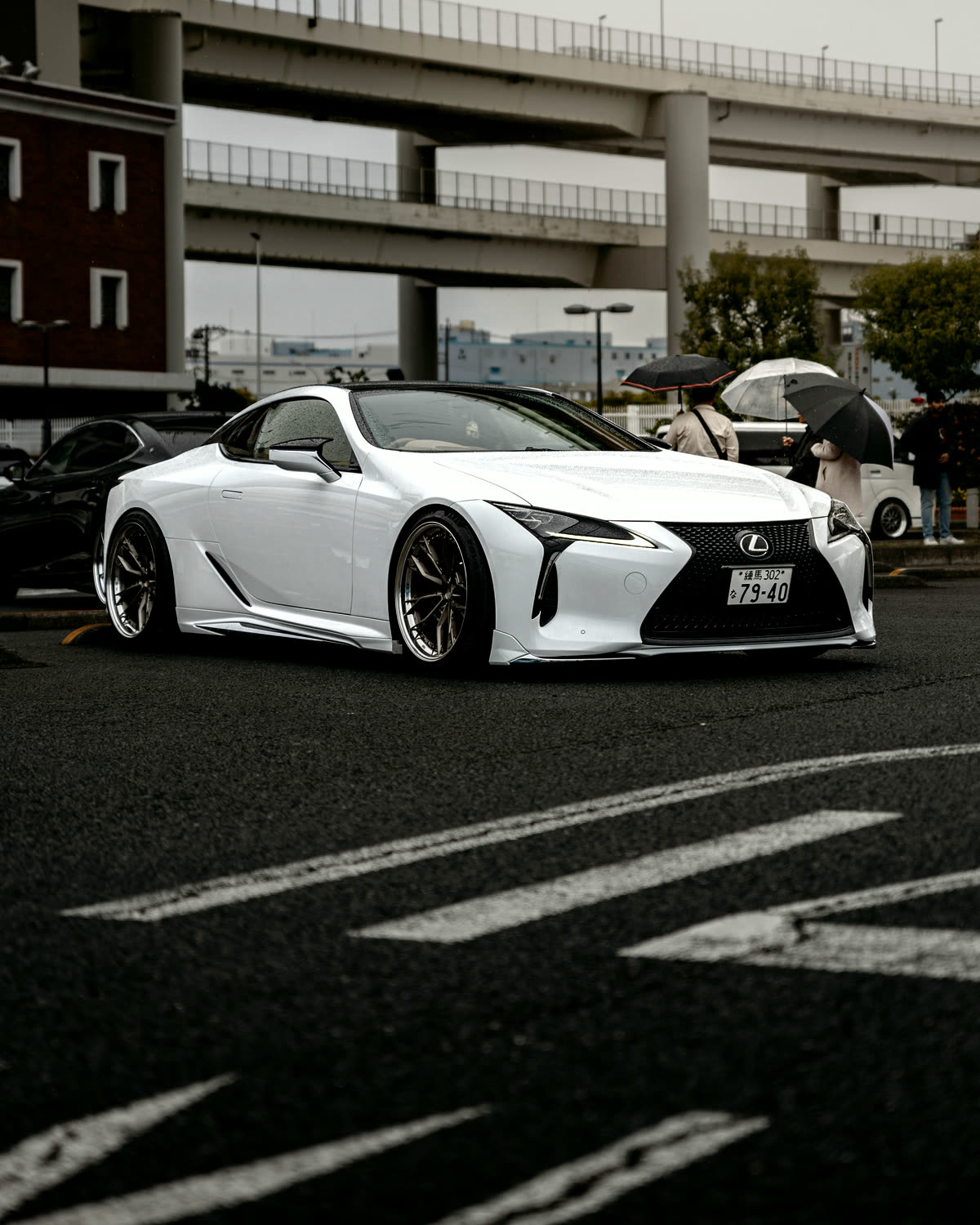Белый Lexus LC 500 под эстакадами скоростной дороги